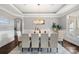 Bright dining room showcasing a grand chandelier, modern decor, and ample seating for hosting dinner parties at 18823 Peninsula Cove Ln, Cornelius, NC 28031