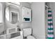 Bathroom with round mirror, steel sink, white toilet and storage creating a functional space at 1924 Lakeview Dr, Rock Hill, SC 29732