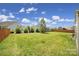 Lush backyard with green grass, trees, and a wood fence at 2015 Knocktree Dr, Indian Trail, NC 28079