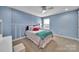 Cozy bedroom with bright blue walls, carpet, and a large window for natural light at 2015 Knocktree Dr, Indian Trail, NC 28079
