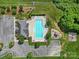 Aerial view of a community pool featuring a playground, lounge seating, and nearby parking area at 2015 Knocktree Dr, Indian Trail, NC 28079