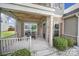 Inviting covered front porch with stone accents, a bench, and a well-maintained garden at 2015 Knocktree Dr, Indian Trail, NC 28079