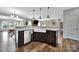 Gourmet kitchen with a large island, a stainless steel dishwasher, and dark wood cabinets at 2015 Knocktree Dr, Indian Trail, NC 28079