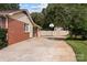 View of the back exterior featuring a brick exterior, driveway, and basketball court at 206 Cedarwood Dr, Salisbury, NC 28147