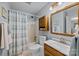 Bathroom featuring a shower with a striped curtain, a wooden cabinet, and ample counter space at 206 Cedarwood Dr, Salisbury, NC 28147