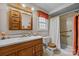 Well-lit bathroom with wood cabinets, a shower with grab bars and modern fixtures at 206 Cedarwood Dr, Salisbury, NC 28147