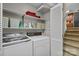 Laundry room equipped with modern washer, dryer, storage shelves, and easy access to stairs at 206 Cedarwood Dr, Salisbury, NC 28147