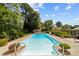 Inviting in-ground pool features ladders and clear water surrounded by lush landscaping, creating a private oasis at 206 Cedarwood Dr, Salisbury, NC 28147