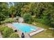 Inviting in-ground pool surrounded by lush landscaping and a spacious patio, perfect for outdoor relaxation at 206 Cedarwood Dr, Salisbury, NC 28147