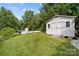 A white storage shed sits on the lush green grass near the pool at 206 Cedarwood Dr, Salisbury, NC 28147