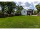A large backyard features a lush lawn, wooden fencing, and the house's exterior with an enclosed sunroom at 2124 Chatham Ave, Charlotte, NC 28205