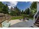 Spacious backyard with a concrete patio, wood fence, green lawn, and comfortable rocking chairs at 2124 Chatham Ave, Charlotte, NC 28205