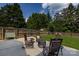Landscaped backyard featuring a concrete patio, rocking chairs, and a cozy fire pit at 2124 Chatham Ave, Charlotte, NC 28205