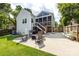 A house backyard showing a patio, rocking chairs, grill, green lawn, and exterior of the home at 2124 Chatham Ave, Charlotte, NC 28205
