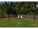 The backyard features a manicured lawn, a wooden fence, and cozy lounge chairs for relaxation at 2124 Chatham Ave, Charlotte, NC 28205