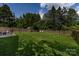 The backyard features a lush green lawn, a wood fence, and comfortable lounge seating at 2124 Chatham Ave, Charlotte, NC 28205