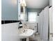 Charming bathroom featuring a pedestal sink, classic tiling, and a well-lit vanity mirror at 2124 Chatham Ave, Charlotte, NC 28205