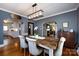 Gray dining room with rustic table, modern light fixture, and arched doorway to the kitchen at 2124 Chatham Ave, Charlotte, NC 28205