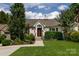 Charming one-story home with an American flag, lush landscaping, a stone chimney, and a well-manicured lawn at 2124 Chatham Ave, Charlotte, NC 28205