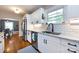 Stylish white kitchen with stainless steel appliances, hardwood floors, and view into the dining room at 2124 Chatham Ave, Charlotte, NC 28205
