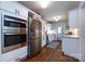 Modern white kitchen featuring stainless steel appliances, hardwood floors, and white subway tile backsplash at 2124 Chatham Ave, Charlotte, NC 28205