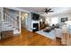 Cozy living room with hardwood floors, a fireplace, a ceiling fan, and a staircase to the upper level at 2124 Chatham Ave, Charlotte, NC 28205