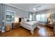 Bright main bedroom with hardwood floors, ceiling fan, and large windows at 2124 Chatham Ave, Charlotte, NC 28205