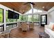 Enclosed porch with wood floors, wicker furniture, mounted television, and views of the surrounding landscape at 2124 Chatham Ave, Charlotte, NC 28205