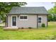 Rear of home featuring neutral siding, small deck, well-kept lawn, and a dark door at 225 N Lee St, Mount Holly, NC 28120
