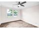 Well-lit bedroom showcasing wood-look flooring, a modern ceiling fan, and a view of the outdoors at 225 N Lee St, Mount Holly, NC 28120