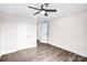 Open bedroom showcasing wood-look flooring, neutral paint, ceiling fan, and white trim at 225 N Lee St, Mount Holly, NC 28120