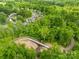 Aerial view shows bridge surrounded by mature trees connecting neighborhood at 229 River Birch Cir, Mooresville, NC 28115