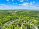 An aerial view reveals a neighborhood surrounded by lush, mature trees and green spaces at 229 River Birch Cir, Mooresville, NC 28115