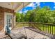 Relaxing back porch featuring a cozy hammock swing, wooden railing, and brick exterior at 229 River Birch Cir, Mooresville, NC 28115