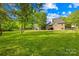 Spacious backyard featuring lush green grass, mature trees, and a view of the home's rear exterior at 229 River Birch Cir, Mooresville, NC 28115