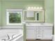 Bathroom with dual vanity, large tub, and a window overlooking the yard; creating a peaceful retreat at 229 River Birch Cir, Mooresville, NC 28115