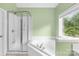 Bathroom featuring a walk-in shower, corner bathtub, and a bright window, creating a spa-like atmosphere at 229 River Birch Cir, Mooresville, NC 28115