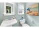 Cozy powder room featuring a pedestal sink, toilet, and artwork; a functional and charming space at 229 River Birch Cir, Mooresville, NC 28115