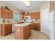 Well-lit kitchen features an island, wooden cabinets, and modern appliances, creating a functional space at 245 Rock Ridge Ln, Mount Holly, NC 28120