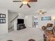 Spacious living room with a ceiling fan, plush carpet, television, and staircase access at 245 Rock Ridge Ln, Mount Holly, NC 28120