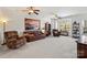 Large, bright living room featuring plush carpet, a ceiling fan, and comfortable furniture at 245 Rock Ridge Ln, Mount Holly, NC 28120