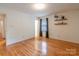 Spacious bedroom with hardwood floors, light walls, floating shelves, and dark curtained window at 2808 Findley Rd, Statesville, NC 28625