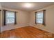 Bright bedroom featuring hardwood floors, two windows, and neutral paint at 2808 Findley Rd, Statesville, NC 28625