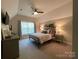 Cozy bedroom featuring a ceiling fan, dresser and a comfortable bed with lamps on the nightstands at 3201 Johnny Cake Ln, Charlotte, NC 28226