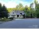 Charming home boasts a landscaped front yard with a covered porch and mature trees providing ample shade at 3201 Johnny Cake Ln, Charlotte, NC 28226
