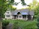 Beautifully landscaped yard with an inviting front porch and mature trees enhancing the home's curb appeal at 3201 Johnny Cake Ln, Charlotte, NC 28226