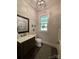 Elegant powder room featuring a decorative mirror, sleek vanity, and stylish modern lighting at 3201 Johnny Cake Ln, Charlotte, NC 28226
