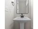 Bathroom features a white pedestal sink, black framed mirror and modern fixtures at 3220 Riley Ave, Charlotte, NC 28269