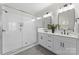 Bathroom with dual vanities, glass shower, and modern fixtures with white subway tile at 3220 Riley Ave, Charlotte, NC 28269