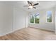 This bedroom features laminate floors, two windows, a closet, and a ceiling fan at 3220 Riley Ave, Charlotte, NC 28269